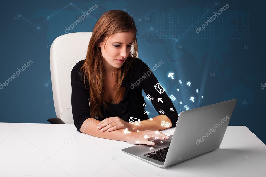 Young lady sitting at dest and typing on laptop with message ico