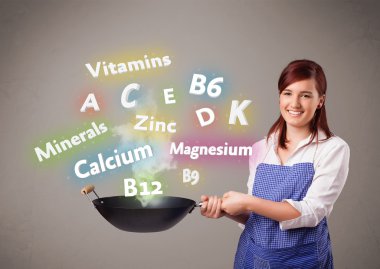 Genç bir kadın vitamin ve mineral pişiriyor.