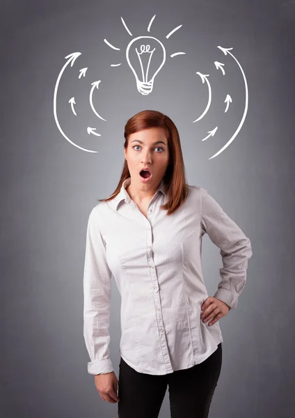 Pretty lady thinking with arrows and light bulb overhead — Stock Photo, Image