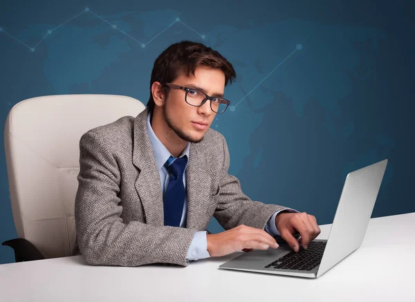 Jovem sentado na mesa e digitando no laptop — Fotografia de Stock