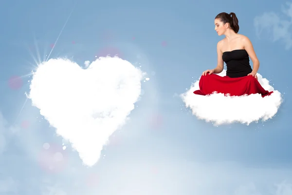 Hermosa mujer encantadora sentada en la nube con el corazón — Foto de Stock