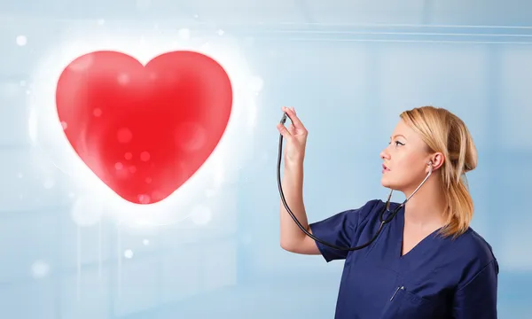 若い看護師が赤い心を癒す — ストック写真