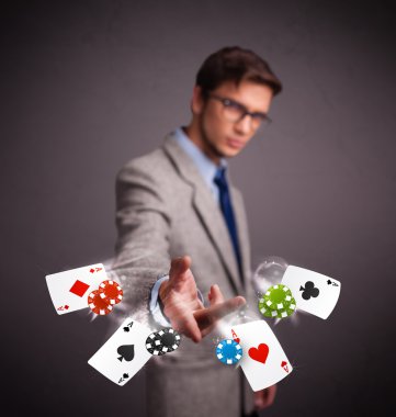 Poker kartları ve fişlerle oynayan genç adam.