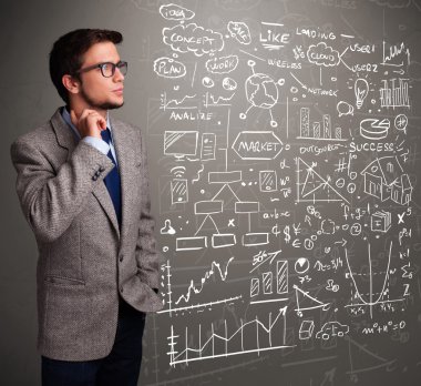 Borsa grafiklerine ve sembollerine bakan çekici bir adam.