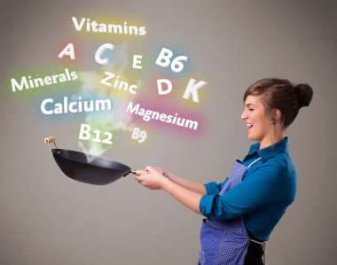 Genç bir kadın vitamin ve mineral pişiriyor.