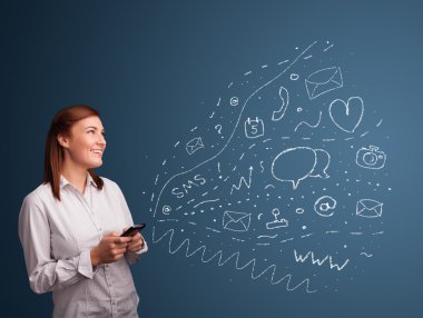 Çeşitli modern teknoloji simgeleriyle akıllı telefonda yazan kız