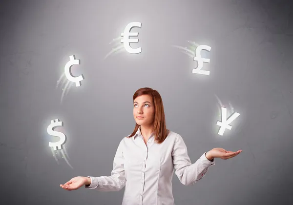 Young lady standing and juggling with currency icons — Stock Photo, Image