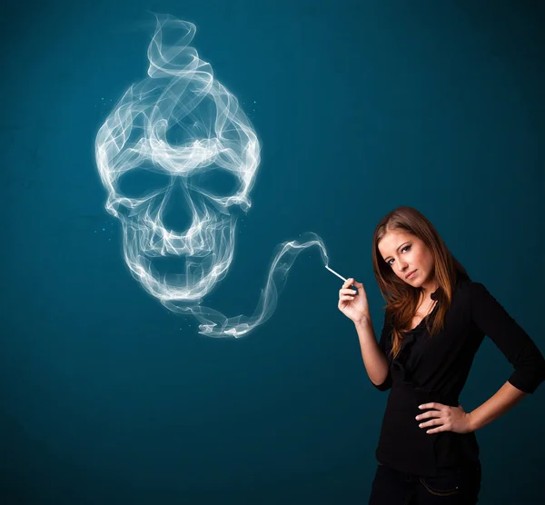 Young woman smoking dangerous cigarette with toxic skull smoke — Stock Photo, Image