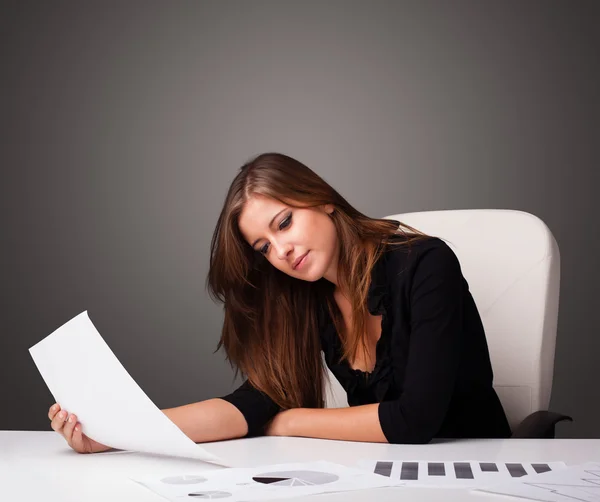 Empresaria sentada en el escritorio y haciendo papeleo — Foto de Stock