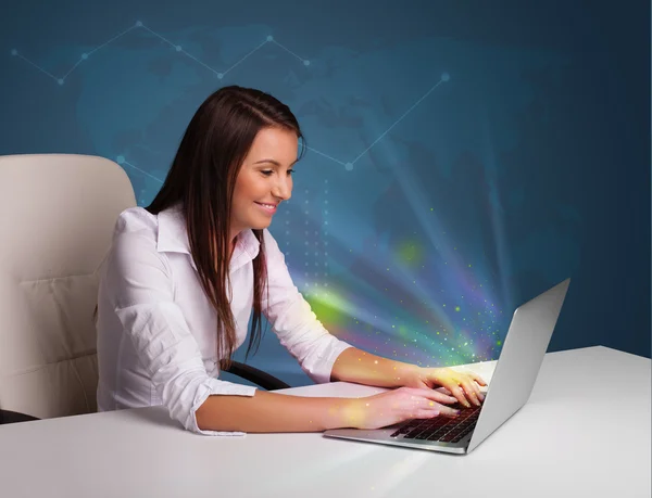 Schöne Frau sitzt am Schreibtisch und tippt auf Laptop mit Abstract — Stockfoto