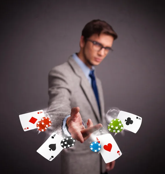 Jeune homme jouant avec des cartes de poker et des jetons — Photo