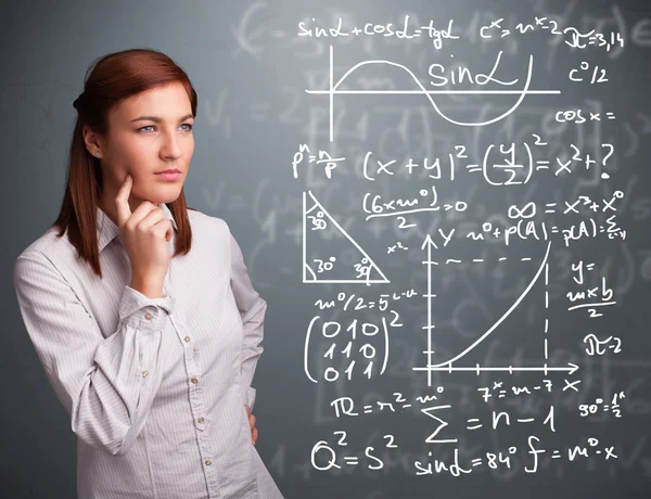 Menina da escola bonita pensando em sinais matemáticos complexos — Fotografia de Stock