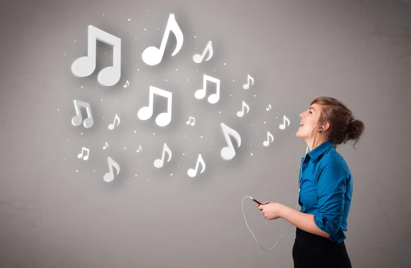 Jolie jeune femme chantant et écoutant de la musique avec n musical — Photo