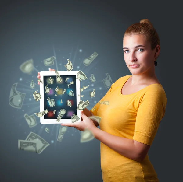 Joven mujer sosteniendo tableta con dinero — Foto de Stock