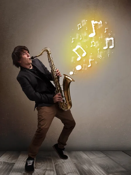 Handsome musician playing on saxophone with musical notes — Stock Photo, Image