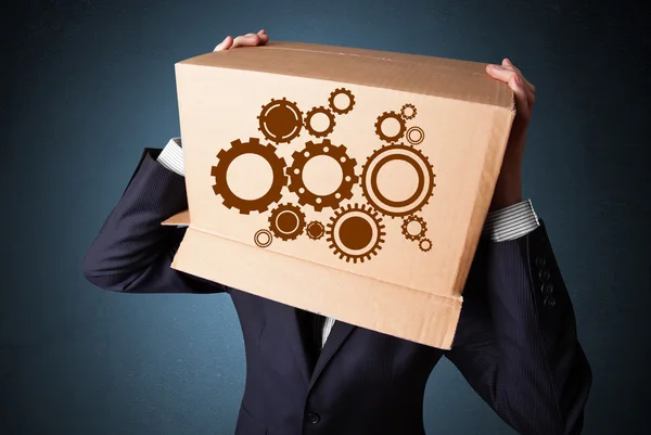 Businessman gesturing with a cardboard box on his head with spur — Stock Photo, Image