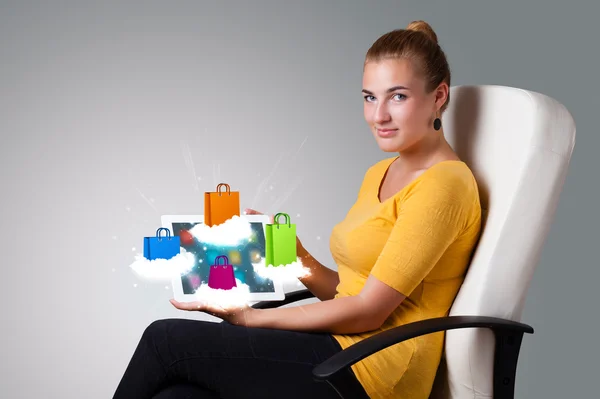 Donna in possesso di tablet moderno con borse colorate sulla nuvola — Foto Stock