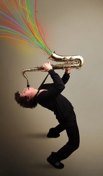 Attractive musician playing on saxophone while colorful abstract — Stock Photo, Image