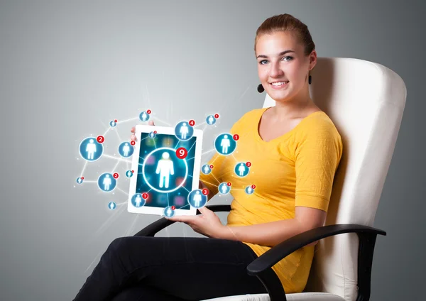 Jeune femme tenant tablette avec des icônes de réseau social — Photo