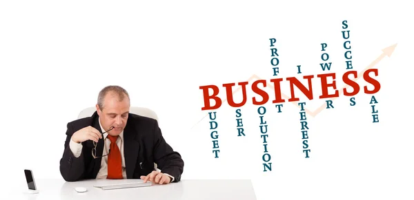 Geschäftsmann sitzt mit Business-Word-Cloud am Schreibtisch — Stockfoto