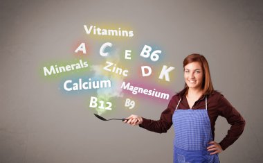 Genç bir kadın vitamin ve mineral pişiriyor.