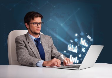 genç adam masada oturan ve diyagramları ile laptop yazarak ve