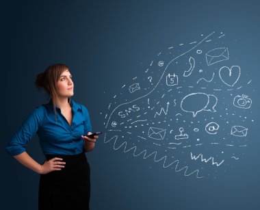 Çeşitli modern teknoloji simgeleriyle akıllı telefonda yazan kız