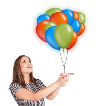 Genç bir kadın elinde renkli balonlar tutuyor.