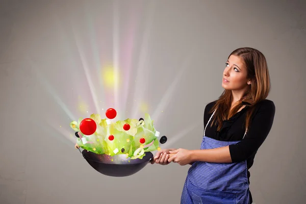 Mujer joven cocinando verduras frescas — Foto de Stock