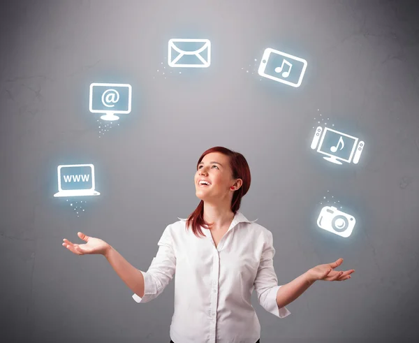 Pretty girl juggling with elecrtonic devices icons — Stock Photo, Image