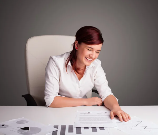 Geschäftsfrau sitzt am Schreibtisch und erledigt Papierkram — Stockfoto