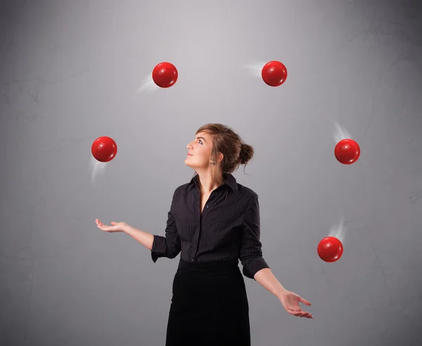Young girl standing and juggling with red balls — Stock Photo, Image