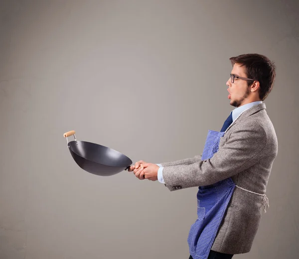 Jovem segurando uma frigideira preta — Fotografia de Stock