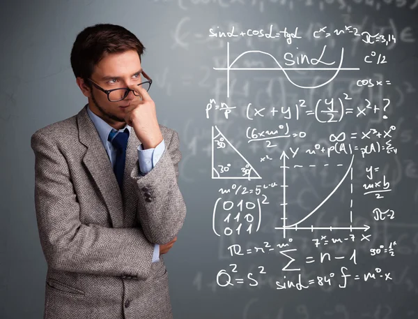 Snygg skolpojke tänker på komplexa matematiska tecken — Stockfoto