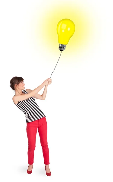 Lycklig kvinna som håller en glödlampa ballong — Stockfoto