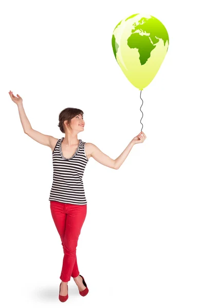 Happy lady holding a green globe balloon — Stock Photo, Image