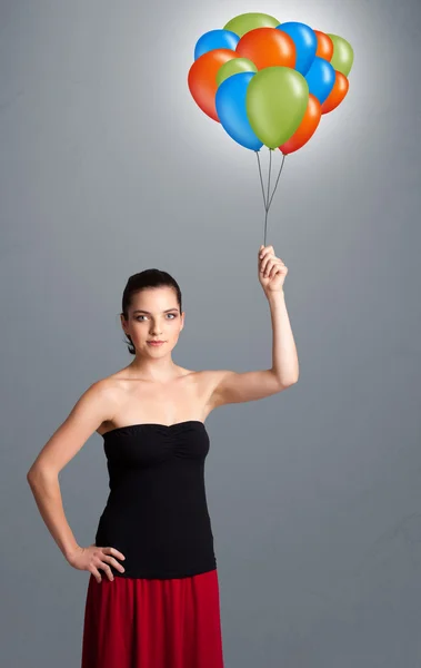 Jeune femme tenant des ballons colorés — Photo