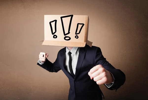 Businessman gesturing with a cardboard box on his head with excl — Stock Photo, Image