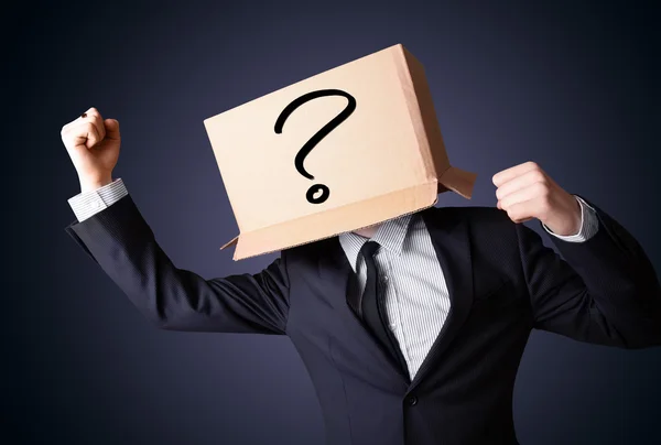 Businessman gesturing with a cardboard box on his head with ques — Stock Photo, Image