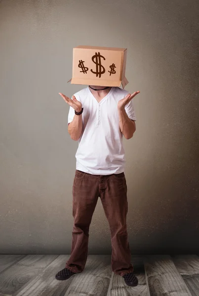 Young man gesturing with a cardboard box on his head with dollar — Stock Photo, Image