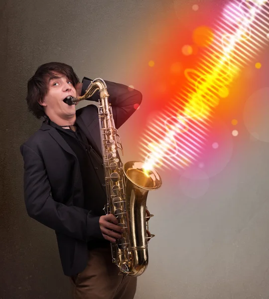 Joven tocando el saxofón con ondas sonoras coloridas —  Fotos de Stock
