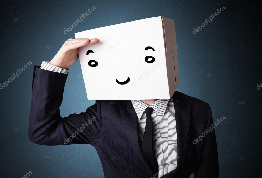 Businessman gesturing with a cardboard box on his head with smil