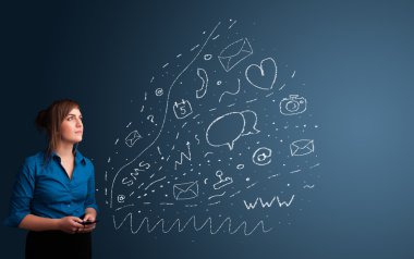 Çeşitli modern teknoloji simgeleriyle akıllı telefonda yazan kız