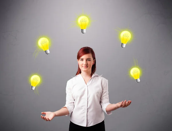 Ung dam som står och jonglerar med glödlampor — Stockfoto