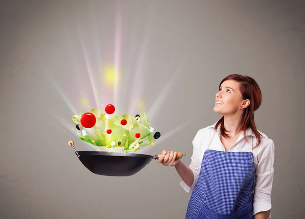 Giovane donna che cucina verdure fresche — Foto Stock