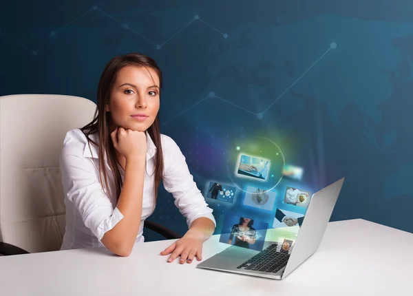 Beautiful girl sitting at desk and watching her photo gallery on — Stock Photo, Image