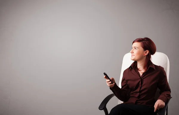 Jovem senhora sentado e segurando um telefone com espaço de cópia — Fotografia de Stock