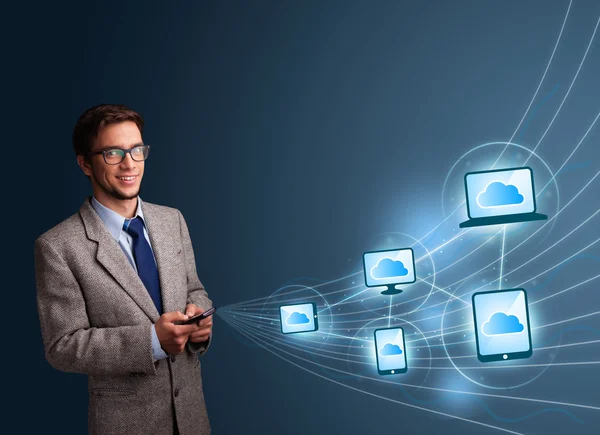 Hombre guapo escribiendo en el teléfono inteligente con computación en la nube —  Fotos de Stock