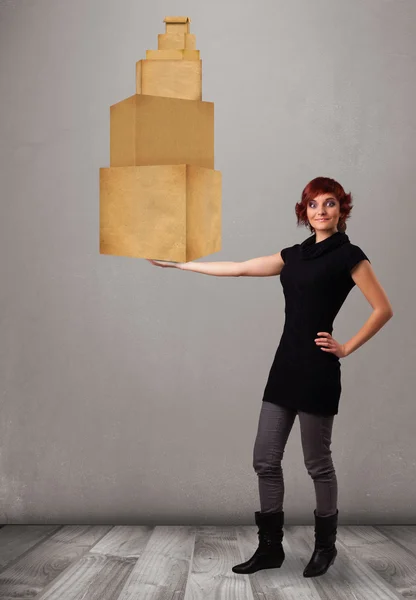 Молодая леди держит набор коричневых картонных коробок — стоковое фото