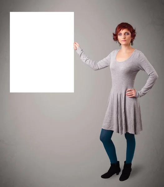 Junge Frau präsentiert Kopierraum aus weißem Papier — Stockfoto